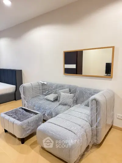 Modern living room with stylish gray sofa and mirror decor