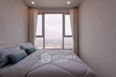 Cozy bedroom with large window offering stunning city view