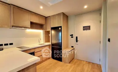 Modern kitchen with sleek wooden cabinetry and integrated appliances in a cozy apartment.