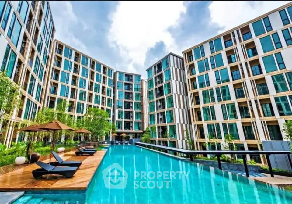 Luxurious modern apartment complex with stunning pool and lush greenery.