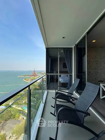 Stunning high-rise balcony with panoramic ocean view and modern seating.