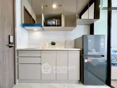 Modern kitchen with sleek cabinetry and stainless steel appliances in a compact layout.