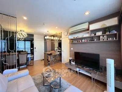 Modern living room with stylish decor and open layout, featuring a cozy seating area and sleek entertainment center.