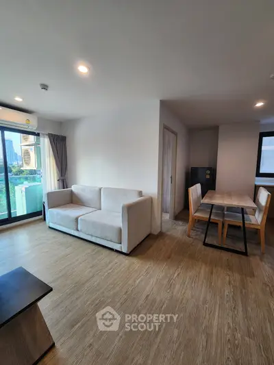 Spacious modern living room with dining area and large windows for natural light.