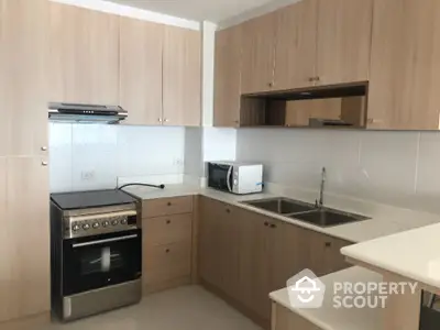 Modern kitchen with wooden cabinets and stainless steel appliances