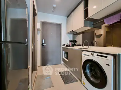 Modern kitchen with sleek appliances and washing machine, compact yet stylish design.