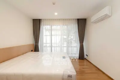 Spacious bedroom with large window and modern air conditioning unit