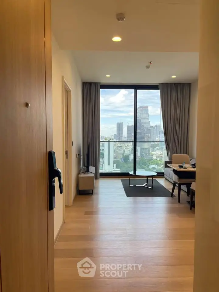Modern living room with city view and floor-to-ceiling windows in a high-rise apartment.