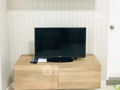 Modern living room with sleek TV stand and flat-screen TV, perfect for entertainment.