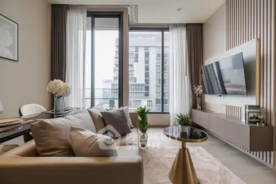 Modern living room with large windows and stylish decor in a high-rise apartment.