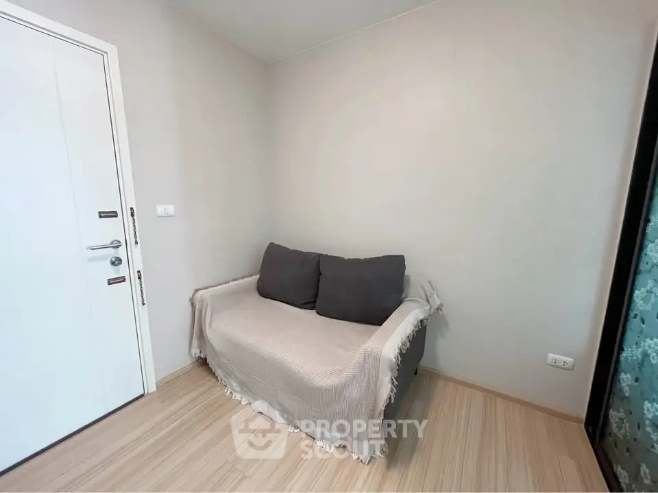 Cozy corner with a small sofa in a minimalist room, perfect for relaxation.