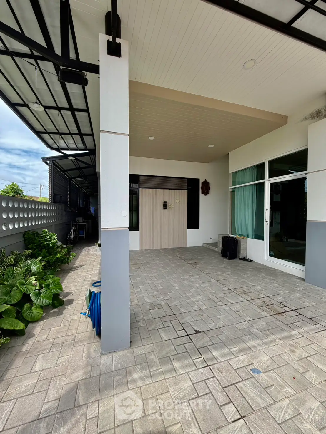 Modern home exterior with covered patio and large glass doors