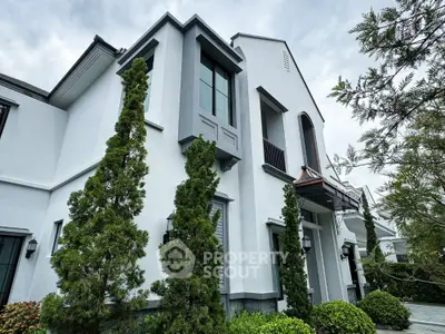 Elegant modern house exterior with lush greenery and stylish architectural design.