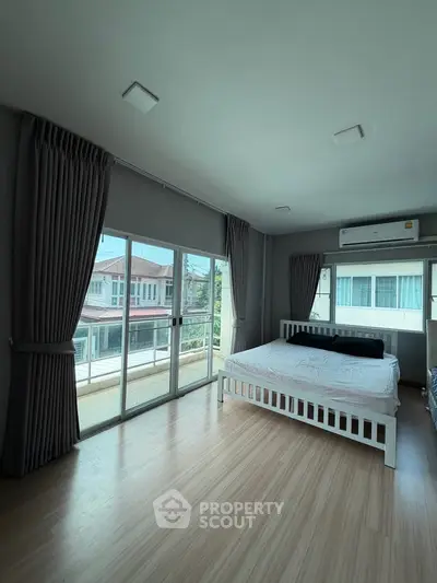 Spacious bedroom with large windows and balcony access in modern home