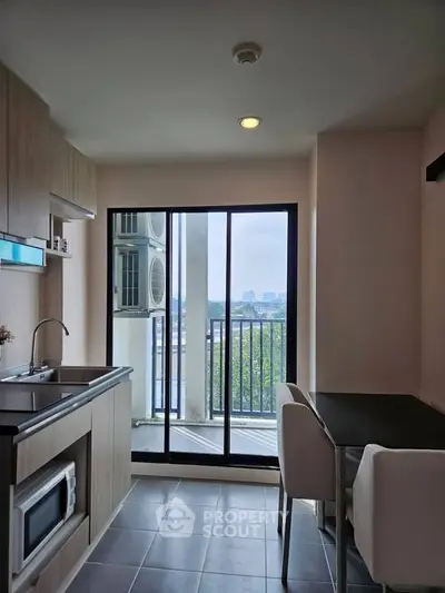 Modern kitchen with open layout and balcony view in a stylish apartment.