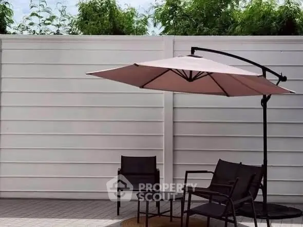 Chic outdoor patio with modern furniture and umbrella, perfect for relaxation and entertaining.