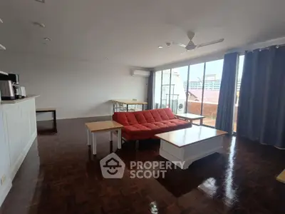 Spacious living room with modern furniture and large windows offering city views.