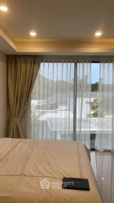 Elegant bedroom with large window and scenic view, featuring cozy curtains and modern design.