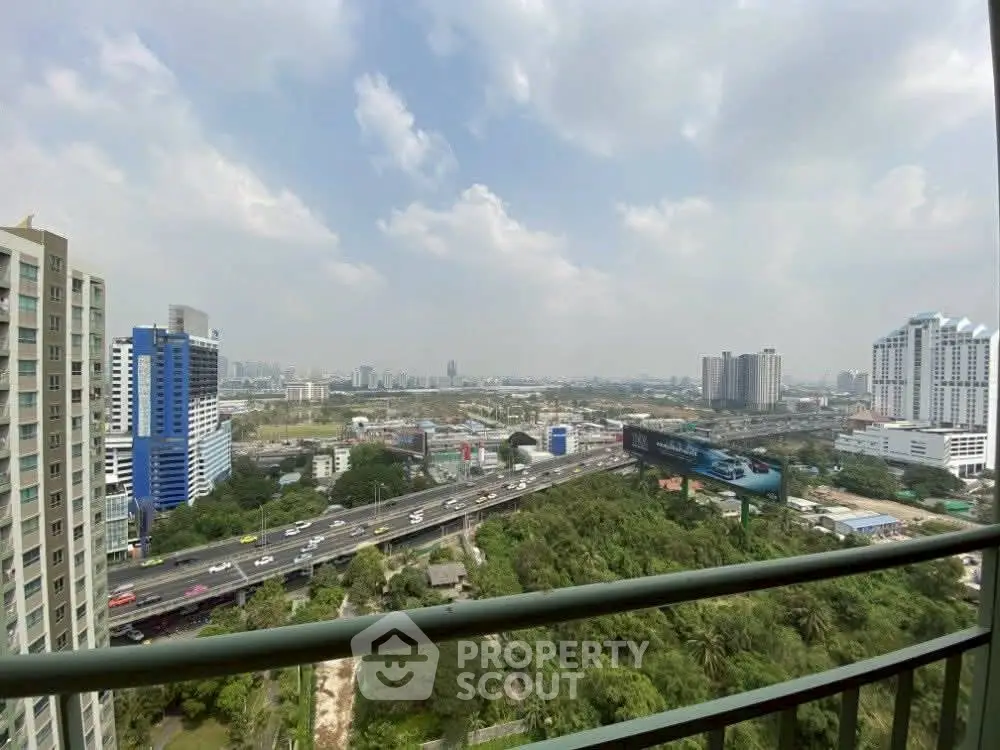 Stunning cityscape view from a high-rise balcony overlooking urban skyline and highway.