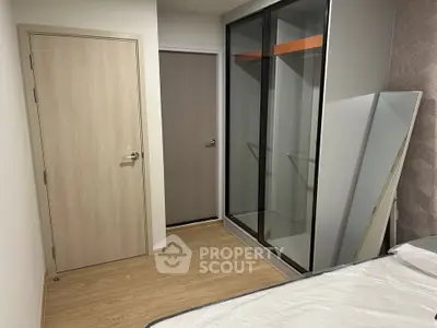 Modern bedroom with sliding glass closet doors and wooden flooring