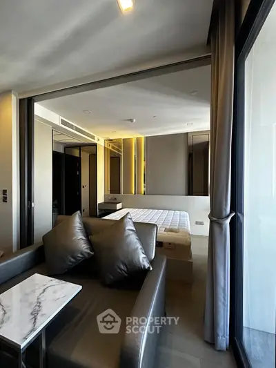 Modern studio apartment with sleek design, featuring a cozy living area and a comfortable bed.