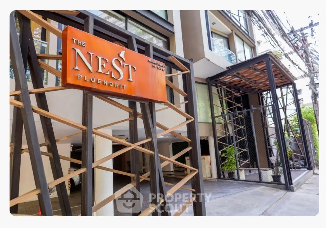 Modern building entrance with stylish signage at The Nest Ploenchit, showcasing contemporary urban living.