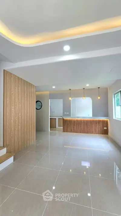 Modern open-plan living room with stylish lighting and sleek tile flooring