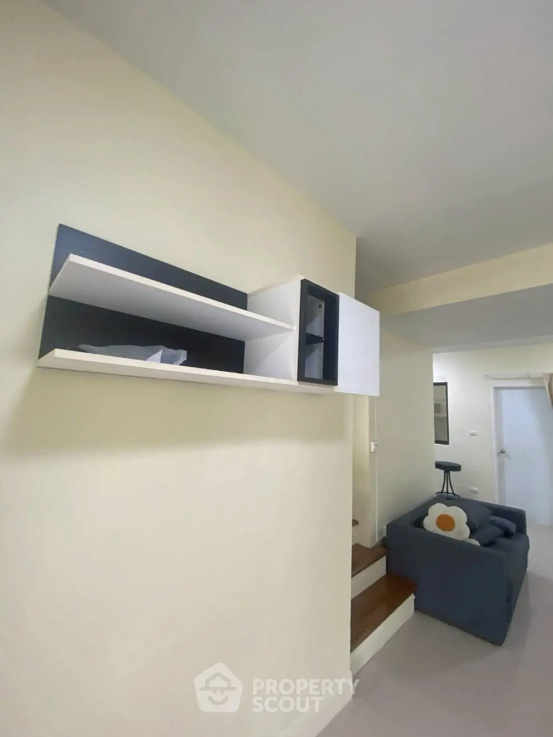 Modern living room with stylish wall-mounted shelves and cozy seating area.