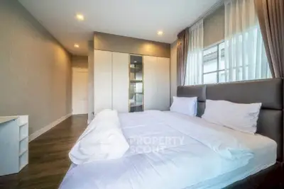 Spacious modern bedroom with large windows and ample natural light