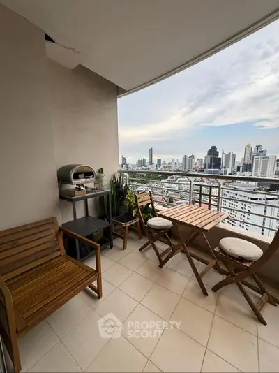 Charming balcony with city skyline view, featuring cozy seating and a compact grill, perfect for urban living.
