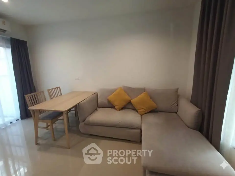 Modern living room with cozy L-shaped sofa and dining table, perfect for relaxation and entertaining.