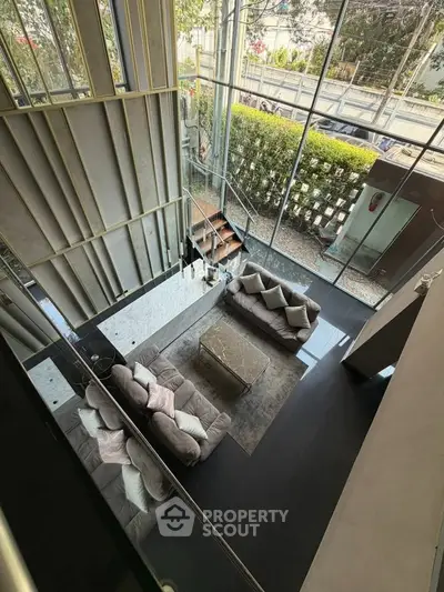 Luxurious modern living room with high ceilings and large windows offering a stunning view.