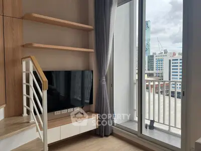 Modern living room with TV and balcony view in urban apartment