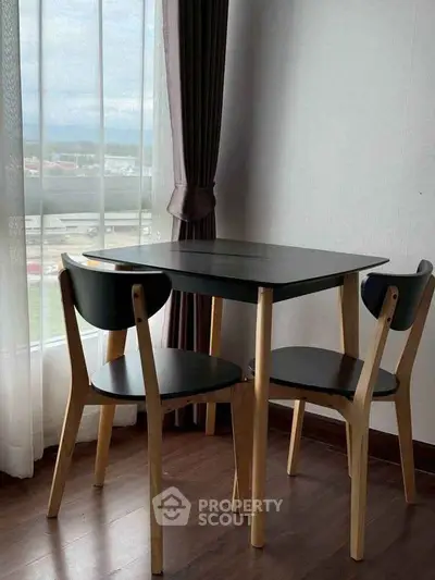Cozy dining nook with modern black table and chairs by a window with a view.