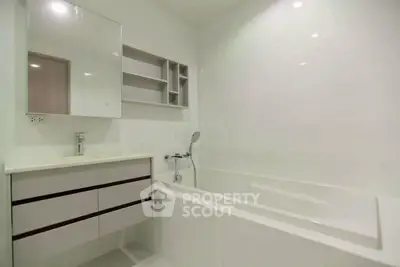 Modern bathroom with sleek white design and built-in bathtub