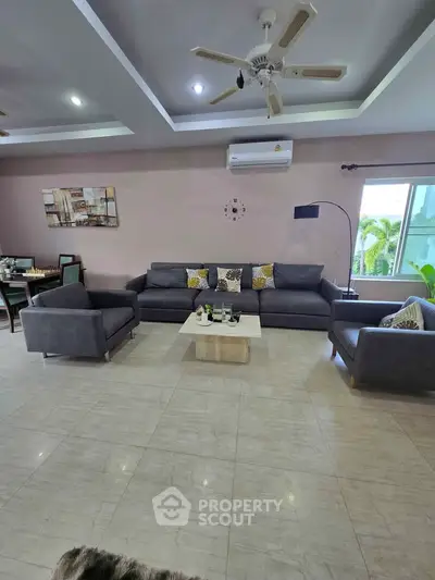 Spacious modern living room with stylish gray sofas and elegant decor, perfect for family gatherings.