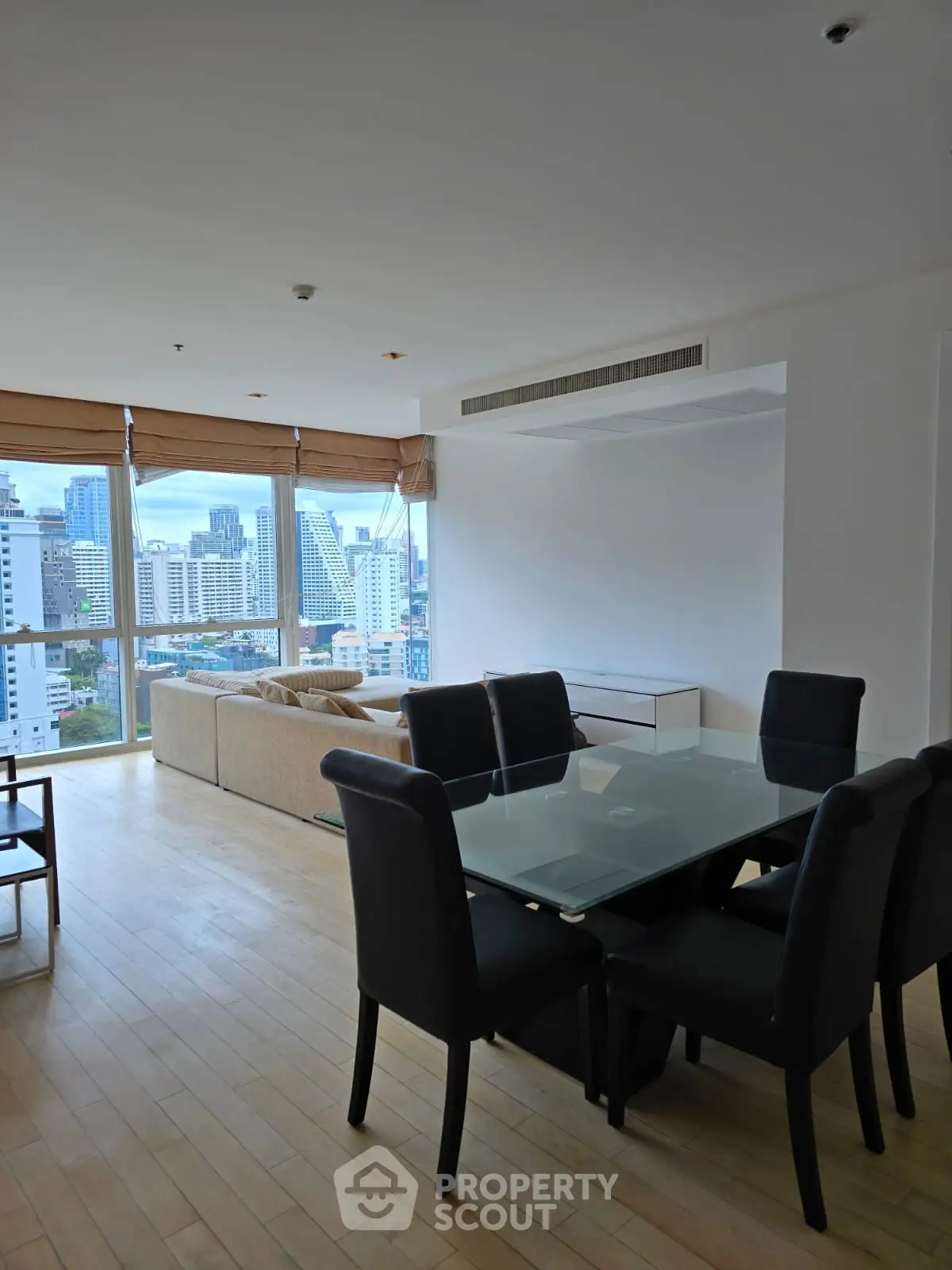 Spacious living room with city view and modern dining area