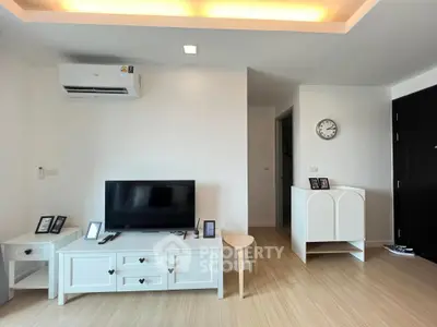 Modern living room with sleek white furniture and wall-mounted air conditioner