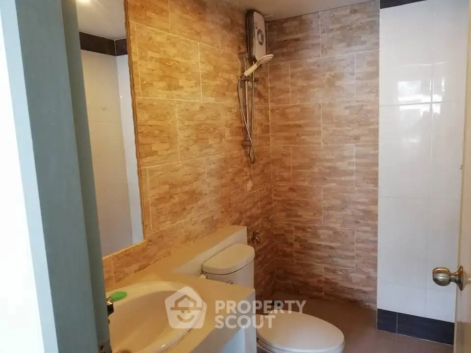 Modern bathroom with stylish tile design and essential fixtures.