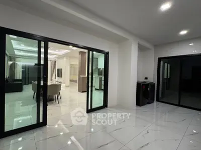 Spacious modern living room with sleek sliding glass doors and elegant lighting