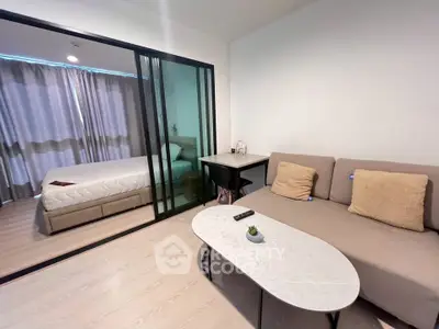 Modern studio apartment with cozy living area and bedroom separated by glass sliding doors.