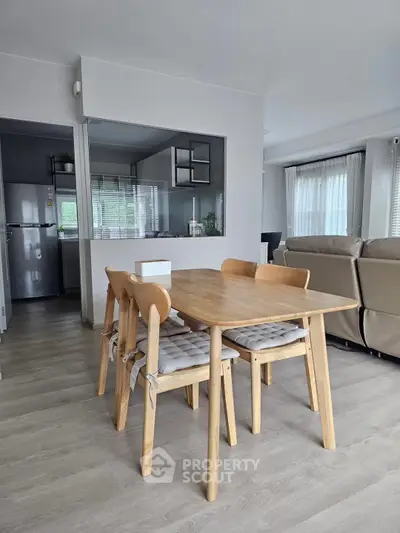 Modern open-plan living and dining area with sleek kitchen and natural light.