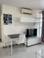 Modern living room with sleek furniture and wall-mounted TV in bright apartment.