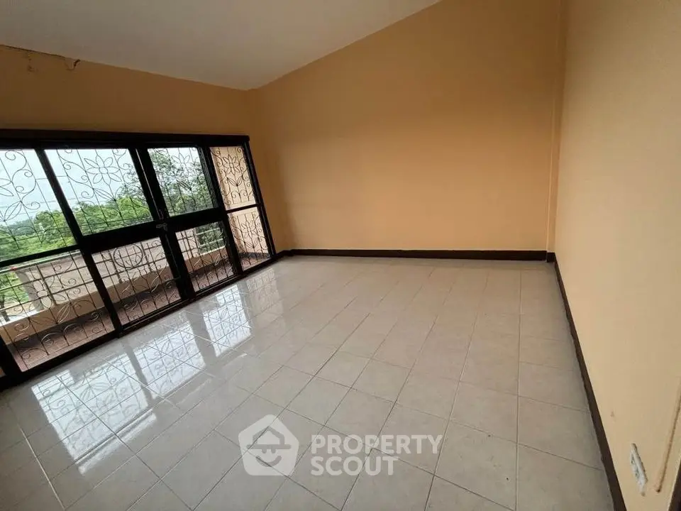 Spacious empty room with large windows and balcony view