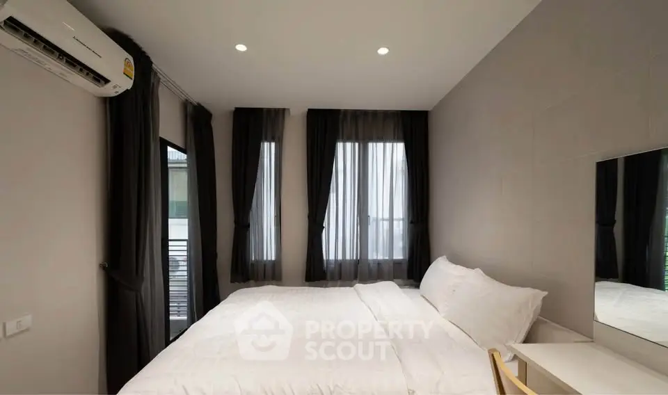 Modern bedroom with sleek design and natural light, featuring a comfortable bed and stylish decor.