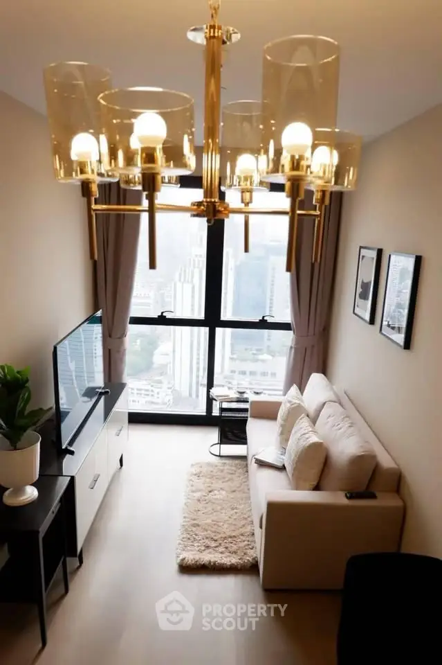 Modern living room with city view, elegant chandelier, cozy sofa, and large window in high-rise apartment.