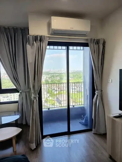 Modern living room with balcony view and air conditioning in a high-rise apartment.
