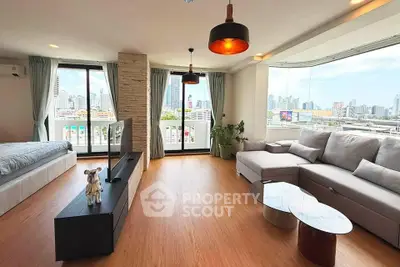 Spacious modern living room with city view, large windows, and stylish decor