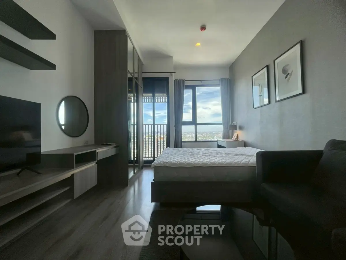 Modern bedroom with large window offering stunning city view, sleek furniture, and stylish decor.