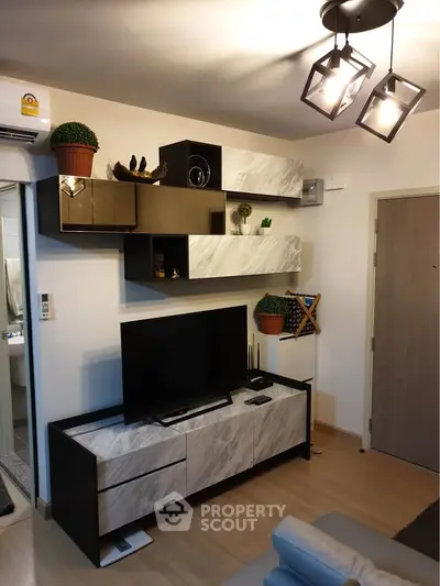 Modern living room with stylish shelving and TV unit, featuring contemporary lighting and decor.